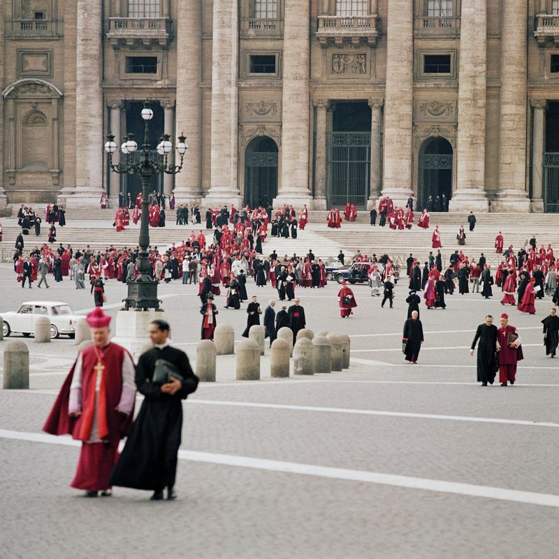 Bishops in choir dress seated in long tiered rows inside St. Peter's Basilica during a working session of the Second Vatican Council.